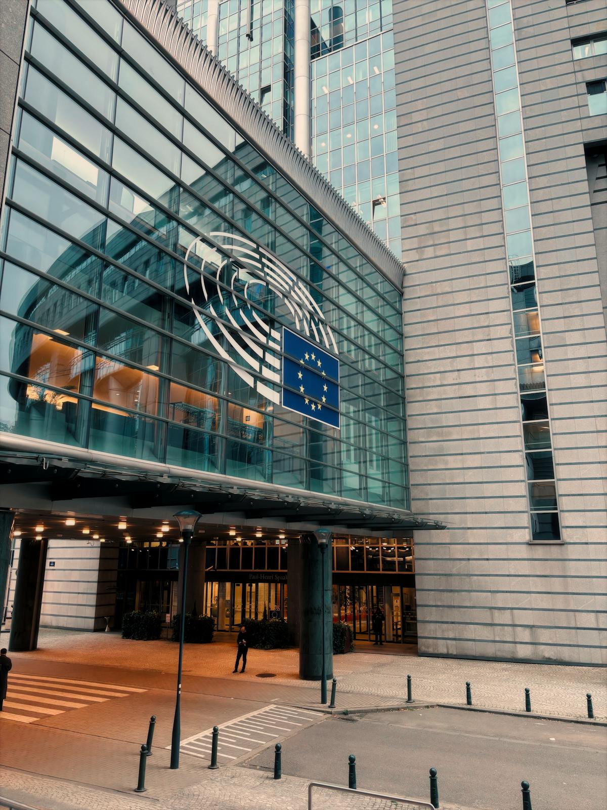 European Parliament building in Brussels where the EU AI Act creates binding regulations contrasting with US White House AI policy framework 2026
